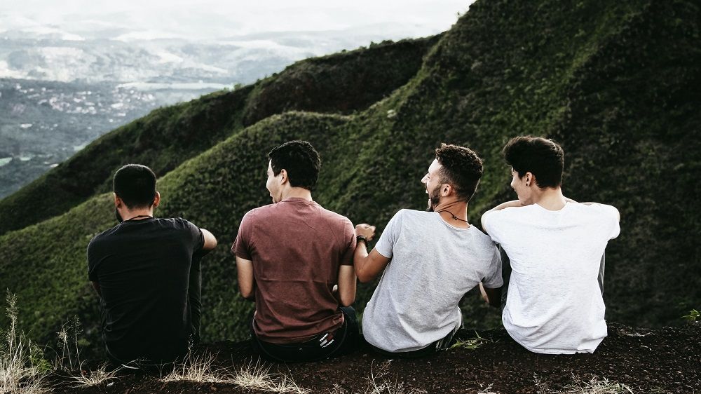 Four men hanging out in the mountains supporting each other through life challenges 